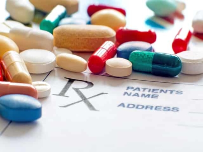 Various medication spilled out on a prescription pad.